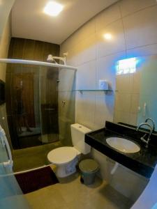 a bathroom with a toilet and a sink at Pousada Ohana Tamandaré in Tamandaré