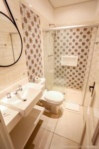 a bathroom with a toilet and a sink and a shower at Siena Hotel in Campos do Jordão