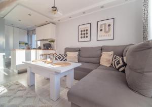 a living room with a couch and a table at Bianco Apartament in Gdynia