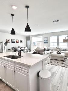 uma cozinha com um lavatório e uma sala de estar em NEW Luxurious 5BR/3BATHES Home, Spacious and Retreat location with Modern Amenities em Ontario