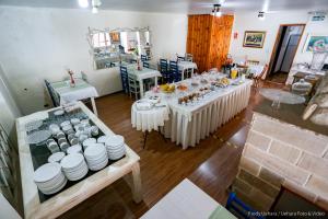 um quarto com uma mesa longa com pratos brancos e tigelas em Siena Hotel em Campos do Jordão