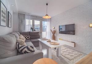 un soggiorno con divano e tavolo di Bianco Apartament a Gdynia