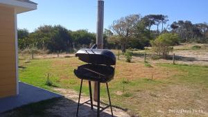 a grill sitting outside of a house with a field at Petrel in La Paloma