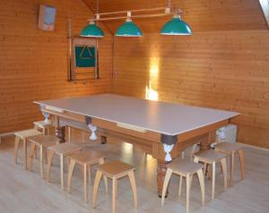 a ping pong table and chairs in a room at Pakavciems pirts in Riga