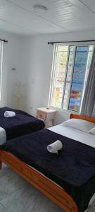 1 dormitorio con 2 camas y ventana grande en APARTAMENTO FAMILIAR MARAL 2 en Salento