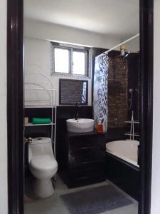 a bathroom with a toilet and a sink and a tub at Q´ojoom Jaay in San Juan La Laguna