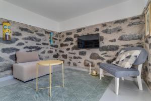 a living room with a couch and a chair and a tv at Passion Villa in Machico