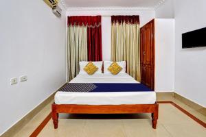 a bedroom with a bed and a television at OYO Majestic Inn in Trivandrum
