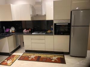 a kitchen with white cabinets and a stainless steel refrigerator at Studio haut standing convivial et bien équipé au coeur de Casablanca in Casablanca