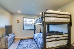a bedroom with two bunk beds and a television at Modern Bozeman Escape with Bridger Mountain Views! in Bozeman