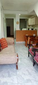 a living room with two chairs and a table and a kitchen at APARTAMENTO FAMILIAR MARAL 2 in Salento