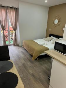 a bedroom with a bed and a desk with a laptop at NICEHOME MASSENA in Nice