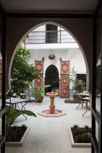 an archway with a fountain in the middle of a courtyard at Origin Hotels Riad Lhena in Marrakesh