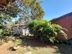 a house with a palm tree next to a building at Pousada Bangalôs Cipó in Serra do Cipo