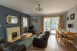 a living room with a couch and a table at GWYNANT BACH - Cosy 2 Bed Bungalow Cottage in Snowdonia National Park, Conwy, North Wales in Conwy