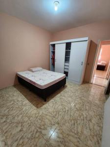 ein Schlafzimmer mit einem Bett in der Ecke eines Zimmers in der Unterkunft Casa em condomínio em Araruama in Araruama
