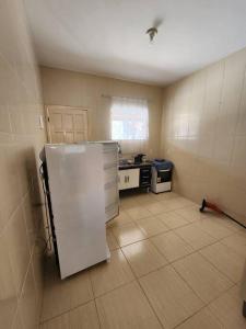 eine Küche mit einem weißen Kühlschrank im Zimmer in der Unterkunft Casa em condomínio em Araruama in Araruama
