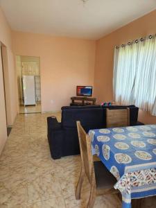ein Wohnzimmer mit einem Tisch und einem Sofa in der Unterkunft Casa em condomínio em Araruama in Araruama