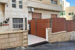 a wooden fence in front of a house at Alrabieh, modern 1-bedroom flat in Amman