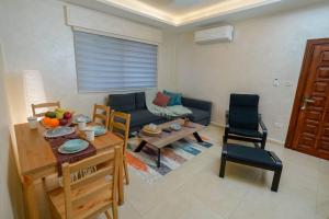 a living room with a couch and a table at Alrabieh, modern 1-bedroom flat in Amman