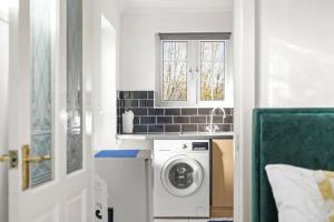 a kitchen with a washing machine and a sink at 1 bedroom flat Aylesbury, Private Parking, Fowler rd in Buckinghamshire