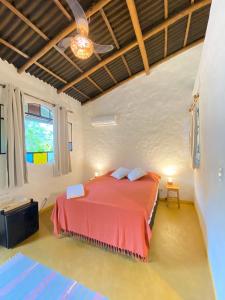 a bedroom with a bed and a ceiling fan at Hospedaria Pimenta Rosa - Serra Grande - BA in Serra Grande