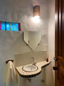 a bathroom with a sink and a mirror at Hospedaria Pimenta Rosa - Serra Grande - BA in Serra Grande