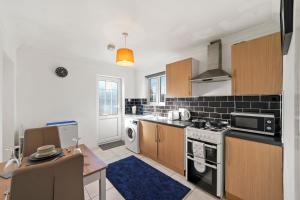 una cocina con fregadero y estufa horno superior en 1 bedroom flat Aylesbury, Private Parking, Fowler rd, en Buckinghamshire