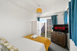 a bedroom with a bed and a tv and a window at 1 bedroom flat Aylesbury, Private Parking, Fowler rd in Buckinghamshire