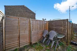 dos sillas frente a una cerca en 1 bedroom flat Aylesbury, Private Parking, Fowler rd, en Buckinghamshire