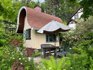 ein kleines Haus mit einem Tisch und einem Sonnenschirm in der Unterkunft Garden Shed R in Hokuto