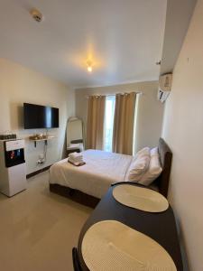 a bedroom with a bed and a table and a tv at Seaside Serenity w/ Sunrise @ Saekyung Village One in Lapu Lapu City