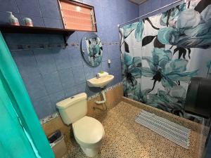 a bathroom with a toilet and a sink at Hotel Sueños de María in Uvita