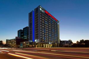 Aloft Perth في بيرث: مبنى طويل وبه أضواء زرقاء وأحمر
