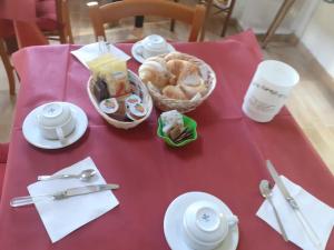 a red table with a basket of food on it at B&B Villa Tina in Alfedena