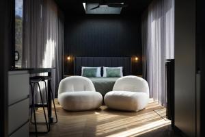 a bedroom with two white chairs and a bed at CABN X Seppeltsfield Barossa in Seppeltsfield