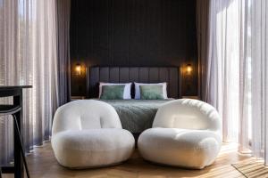 a bedroom with two white chairs and a bed at CABN X Seppeltsfield Barossa in Seppeltsfield