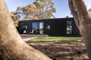 a black house with a view of the backyard at CABN X Seppeltsfield Barossa in Seppeltsfield
