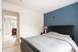 a bedroom with a large bed with a blue wall at Lovely one bedroom flat. in Belfast