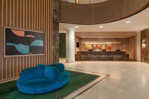 a lobby with a blue chair and a bar at Four Points by Sheraton Lagos in Lagos