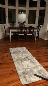 a dining room with a table and chairs and a rug at The barn in Croydon