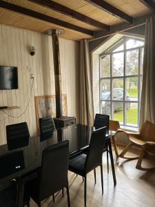 a dining room with a table and chairs and a window at QUELEN AUSTRAL in Hornopiren