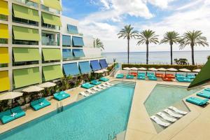 uma imagem de um resort com uma piscina e cadeiras em W Ibiza em Santa Eulària des Riu