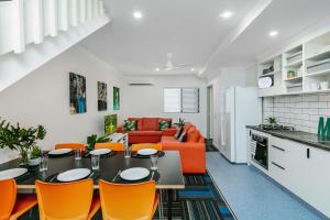 una cucina e un soggiorno con tavolo e sedie arancioni di MiHaven Shared Living - Gatton St a Cairns