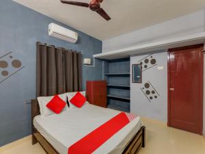 a bedroom with a bed with red pillows and a ceiling at Vsv Guest House Maduravoyal in Chennai