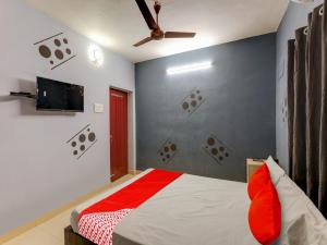 a bedroom with a bed and a flat screen tv at Vsv Guest House Maduravoyal in Chennai