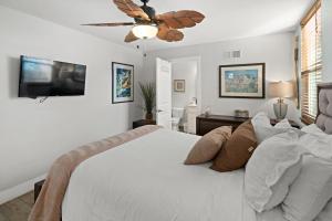 um quarto com uma cama branca e uma ventoinha de tecto em Stunning Beach Home - large patio, parking, ac & dog friendly! em San Diego