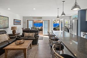 a kitchen and living room with a counter and a table at Stunning Beach Home - large patio, parking, ac & dog friendly! in San Diego