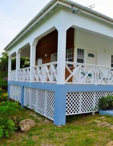 的住宿－Pearl's Hilltop Cottage，白色和蓝色的房子,设有门廊