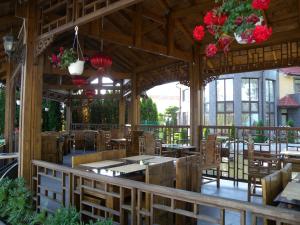 a restaurant with wooden tables and chairs and flowers at Motel DHS - Chinese Restaurant in Deva